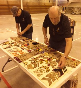 Ted Leaker and Dave Newton sort a newly donate badge collection