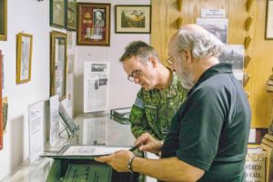 Museum Director Ted Leaker discusses a museum artefact with Div Comd.